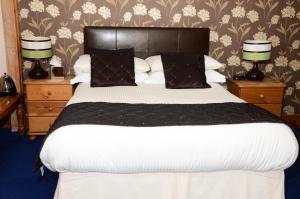 1 dormitorio con 1 cama grande y 2 mesitas de noche en Pinewood House, en Whitby