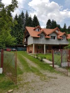a house with a fence in front of it at Cabana Merișor in Poiana Mărului