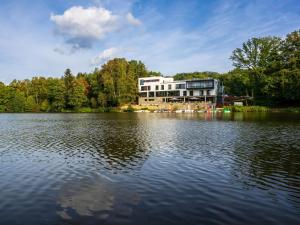 ein großes Gebäude auf der Seite eines Sees in der Unterkunft PETERS Hotel & Spa in Homburg