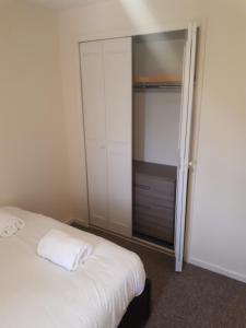 a bedroom with a white bed and a closet at Marvellous Meridian Maisonette in Ifield
