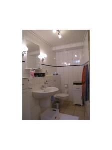 ein weißes Bad mit einem Waschbecken und einem WC in der Unterkunft Theodor Storm Unterkünfte 2 in Husum
