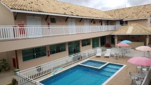 vue aride d'un hôtel avec un billard, des tables et des parasols dans l'établissement Pousada Peruíbe Ametista, à Peruíbe