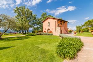 una casa con un césped verde delante de ella en Tenuta Quadrifoglio, en Gambassi Terme