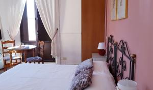 a bedroom with a bed and a table and a window at Villa Floresta Taormina in Taormina