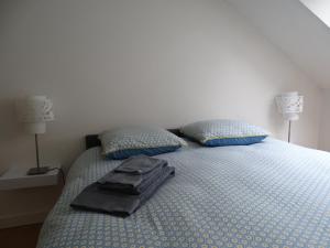 Una cama con dos almohadas y una bolsa negra. en Le Loft, l'annexe, en Lorient