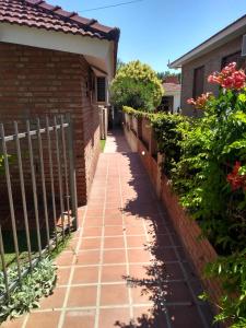 Una pasarela de ladrillos al lado de una casa con una valla en Departamento Con Vistas a La Montaña, en Villa Carlos Paz
