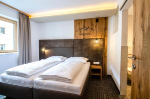 two beds in a hotel room with a headboard at Chalet M in Ischgl