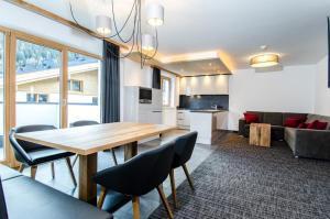 a kitchen and living room with a wooden table and chairs at Chalet M in Ischgl