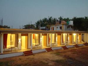 a building with yellow doors and windows at night at Cassiopeia Nest in Arambol