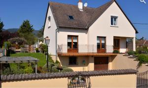 a white house with a balcony and a yard at Fleur de Vigne in Eguisheim