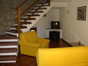 a living room with a yellow chair and stairs at Bricco di Sant' Eufemia in Bossolasco