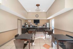 a dining room with tables and chairs and a bar at Super 8 by Wyndham North Little Rock/McCain in North Little Rock