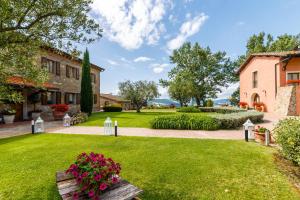 a garden with a bench and flowers in front of a building at Tenuta Quadrifoglio in Gambassi Terme