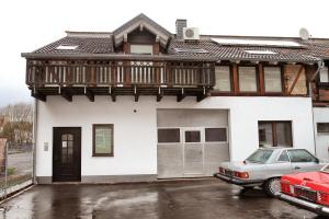ein weißes Haus mit einem Balkon und einem Auto vor dem Haus in der Unterkunft Oppenheimstrasse 2 in Eisenach