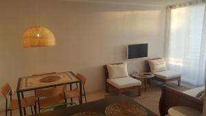 sala de estar con sofá, sillas y TV en Dpto Marina Oceano, en Coquimbo
