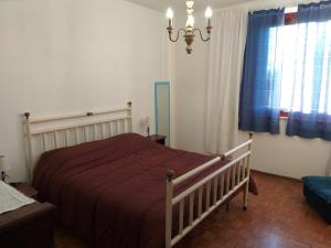 - une chambre avec un lit doté d'une couverture rouge et d'une fenêtre dans l'établissement Casa SoleLuna, à Sienne