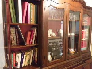 estantería de madera con libros y espejo en Casa SoleLuna, en Siena