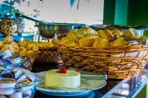 a table topped with baskets of bread and a cake at Balneário do Lago Hotel in Capitólio