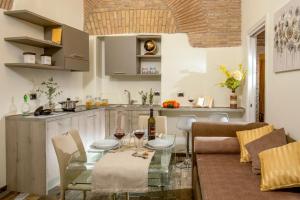 a kitchen and a living room with a glass table at Guesthouse MySuiteTower Pantheon in Rome