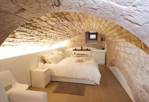 a bedroom with a bed in a stone wall at Gino's house in Old Town.. in Gubbio