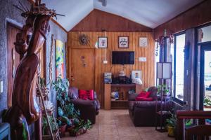 un soggiorno con divani e TV di Cabañas & Hostal Tojika a Hanga Roa