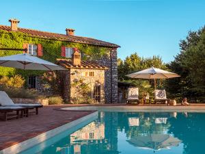 a house with a swimming pool with two umbrellas at Villa Fonteintanata in Miemo