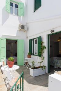 a patio with green doors and a table and chairs at Villa Areto in Kamares