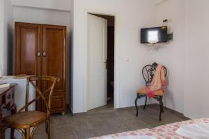 a room with two chairs and a television on a wall at Villa Areto in Kamares