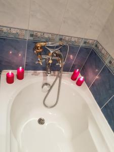 a bath tub with candles and a faucet at Guest House Karov - 2 Stars in Chepelare