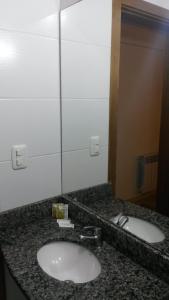 a bathroom counter with two sinks and a mirror at Hotel Concatto in Farroupilha