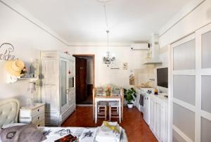 a kitchen with white cabinets and a table at La Bomboniera Chic di Pietrasanta in Pietrasanta