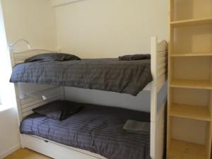 um quarto com 2 beliches e uma pequena cama em B and B Sycomore, La Bouriotte em Labastide-Rouairoux