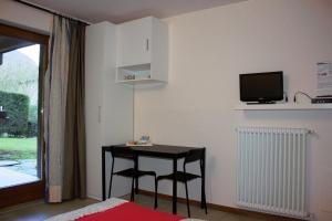 a room with a table and two chairs and a tv at Villa Tre Cariole in Colico