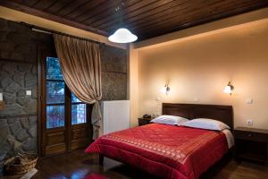a bedroom with a red bed and a window at Hotel Kroupi in Elati Trikalon