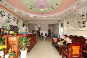 a woman sitting at a bar in a restaurant at Rang Dong Hotel in Mỹ Tho