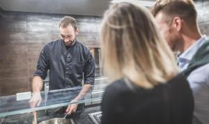 Ein Mann und eine Frau bereiten in einer Küche Essen zu in der Unterkunft Molaris Lodge in Mühlbach + 37 Fotos