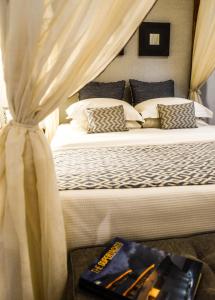 een slaapkamer met een bed met gordijnen en een boek bij 5inAthens in Athene