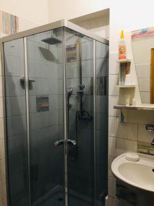 a glass shower in a bathroom with a sink at Penzion u modrého zvonku in Zlaté Hory