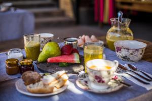 una mesa cubierta con platos de fruta y una taza de café en Hotel Desertica, en San Pedro de Atacama