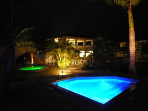 a swimming pool at night with a house in the background at Jabaquara Beach Resort in Paraty
