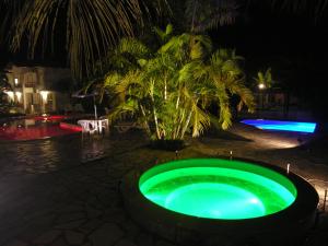 uma piscina verde no meio de um quintal à noite em Jabaquara Beach Resort em Paraty