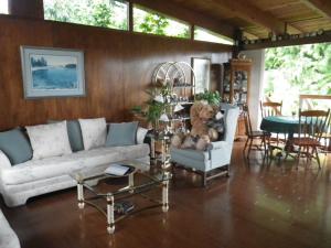 a living room with a couch and a teddy bear at Beach Estates Inn Bed and Breakfast in Nanaimo