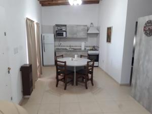 a kitchen with a table and chairs in a room at Complejo La Palmera in San Rafael