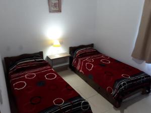 two beds sitting next to each other in a bedroom at Complejo La Palmera in San Rafael