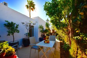 a table and chairs on a patio with trees at Villa Mateo in Playa del Ingles