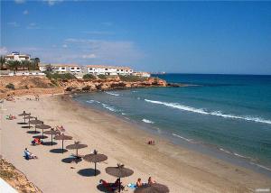 plaża z wieloma parasolami i ludźmi na plaży w obiekcie Casa Marina La Zenia w mieście Orihuela