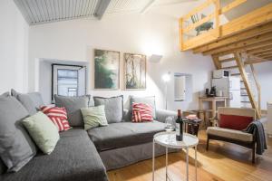 a living room with a gray couch and a loft at Apartments Center Bairro Alto in Lisbon