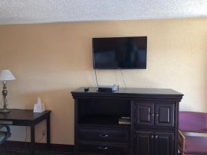 a flat screen tv on a wall in a hotel room at Dogwood Park Inn in Springfield