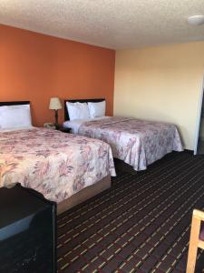a hotel room with two beds and a flat screen tv at Dogwood Park Inn in Springfield