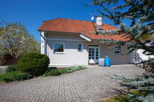 ein weißes Haus mit einem roten Dach und einer Auffahrt in der Unterkunft IdyllicPrague Cherry Tree Cottage in Černý Vŭl